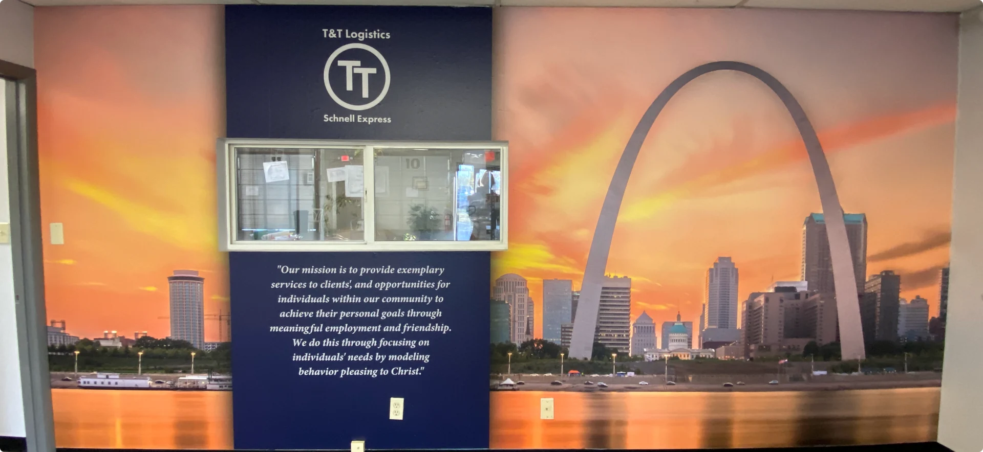 The T&T Logistics office mural with the St. Louis Gateway Arch and the company’s Christ-centered mission
